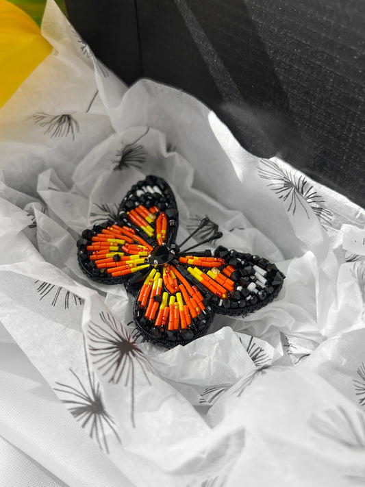 Monarch butterfly beaded brooch on a white tissue background