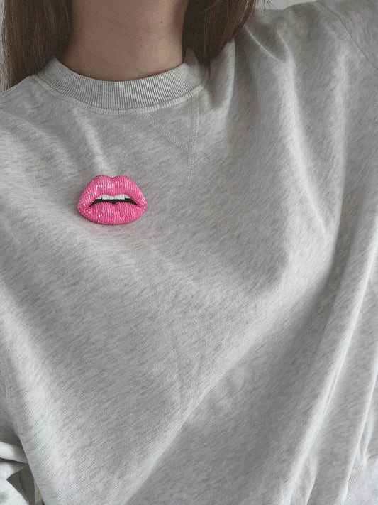 Gray sweatshirt with a pink lips brooch