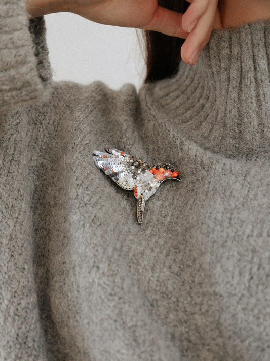 Robin bird beaded brooch on a gray sweater