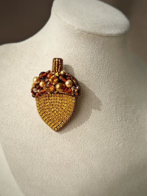 acorn brooch with gemstones on a mannequin bust