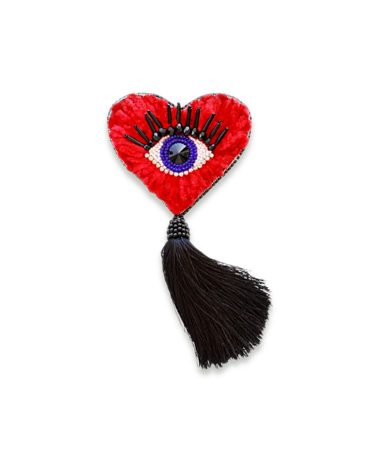 Heart-shaped brooch with an eye design and black hanging tassel.