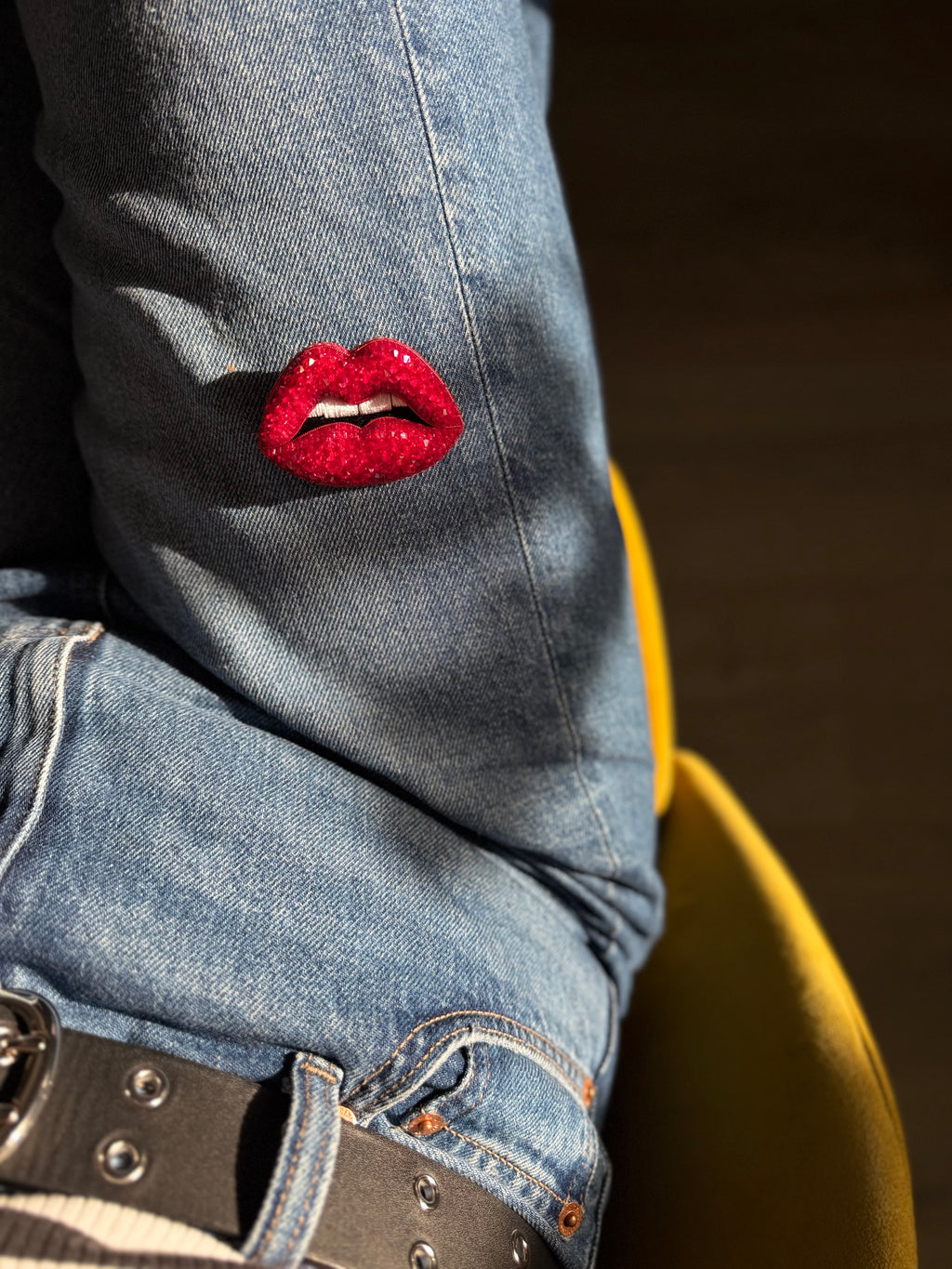 Red lip brooch displayed on a denim 