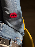 Red lip brooch displayed on a denim 