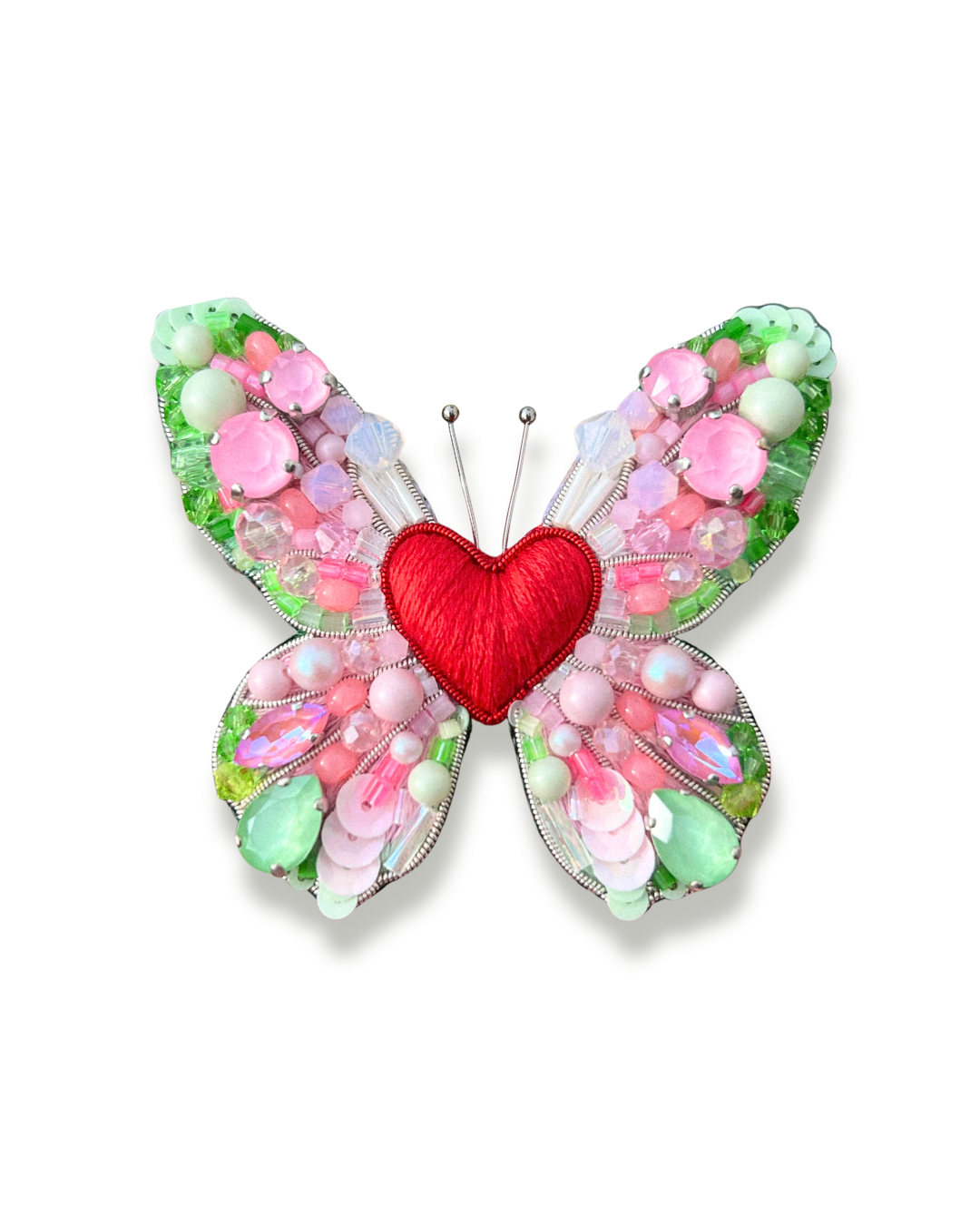 Pastel color beaded butterfly shaped brooch with a red heart in center.