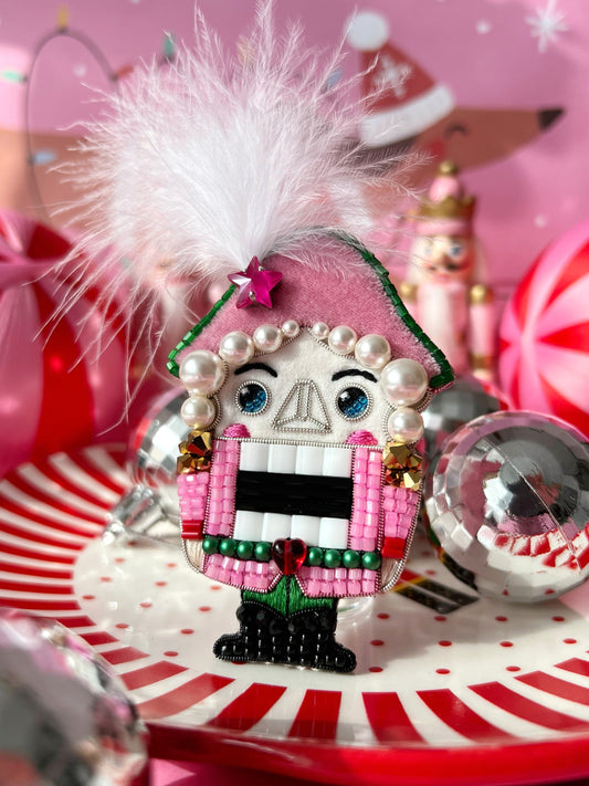 Nutcracker brooch with pink outfit, green belt and Swarovski pearl hairs.